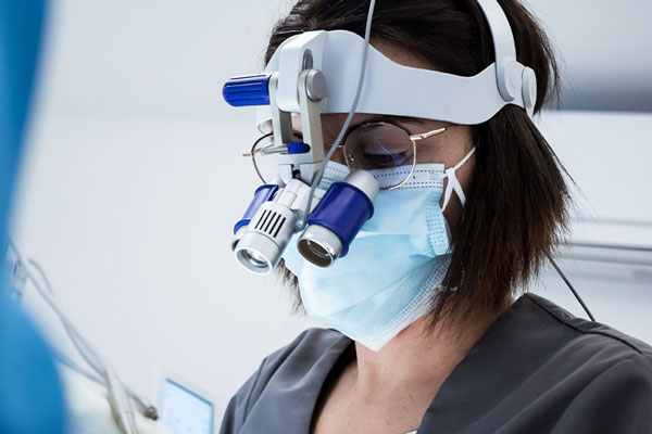 dentista realizando una apicectomia con microscopio dental